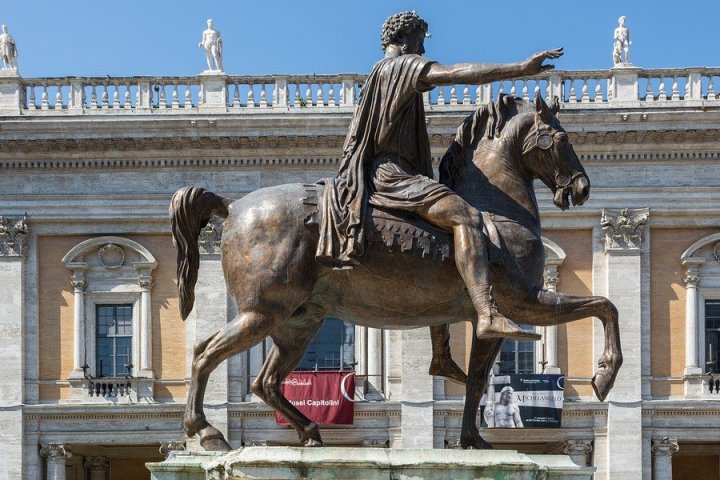 a statue of a person riding a horse in front of a building