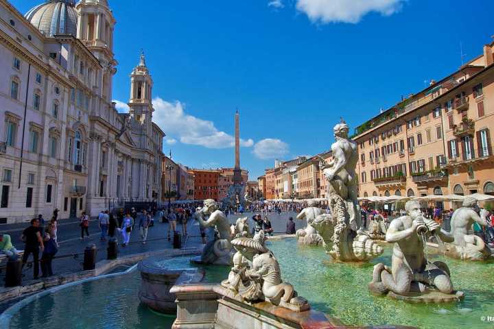 a group of people standing in front of a statue with Piazza Navona in the background