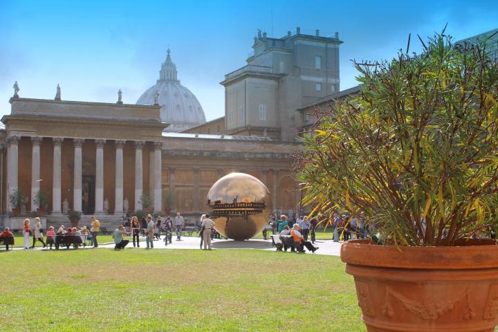 a large white building with grass and trees