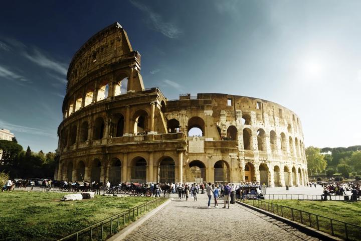 a large stone building with Colosseum in the background