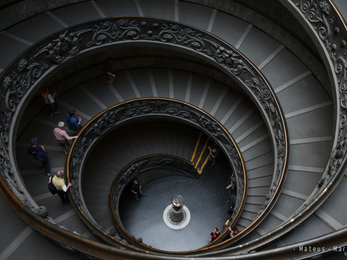a large clock mounted to the side of Vatican Museums