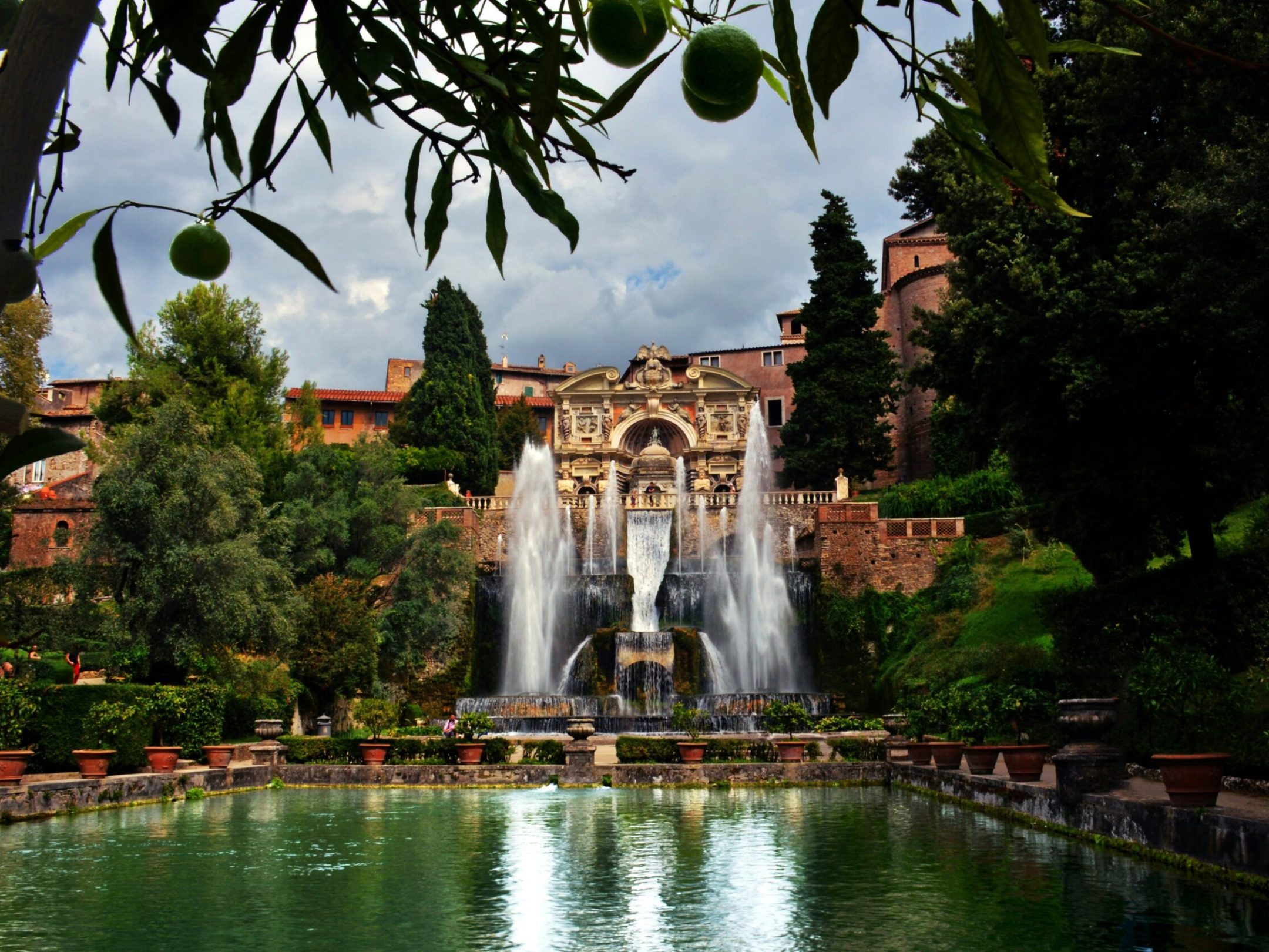 a large waterfall over some water with Villa d'Este in the background
